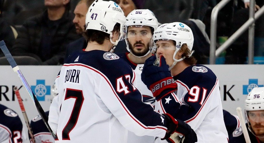 Columbus Blue Jackets defenseman Marcus Bjork and right wing Kirill Marchenko and center Kent Johnson talk before a face-off against the Pittsburgh Penguins during the third period.