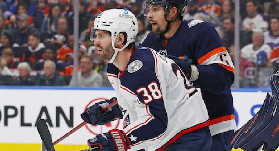 Boone Jenner and Cody Ceci battle in front of the net.