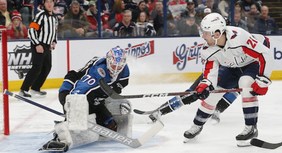 Joonas Korpisalo makes a save on Garnet Hathaway in the Blue Jackets vs. Capitals game.
