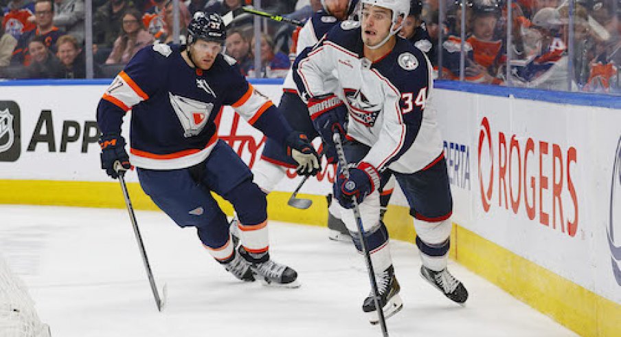 Cole Sillinger skates with the puck behind the net in the Blue Jackets vs. Oilers game.