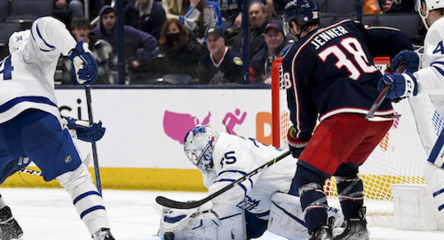 Maple Leafs goalie Petr Mrazek stops a puck while Boone Jenner is in the crease.