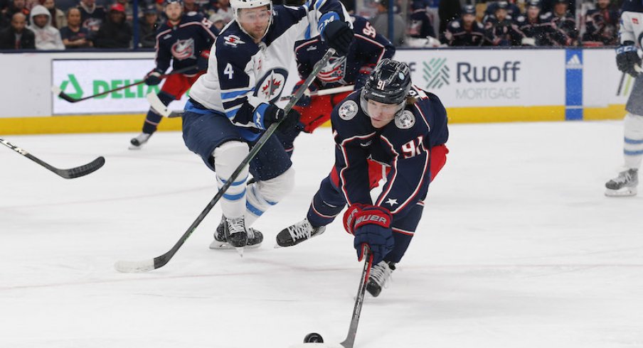 Columbus Blue Jackets' Kent Johnson regains possession of the puck as Winnipeg Jets' Neal Pionk defends during the second period at Nationwide Arena.