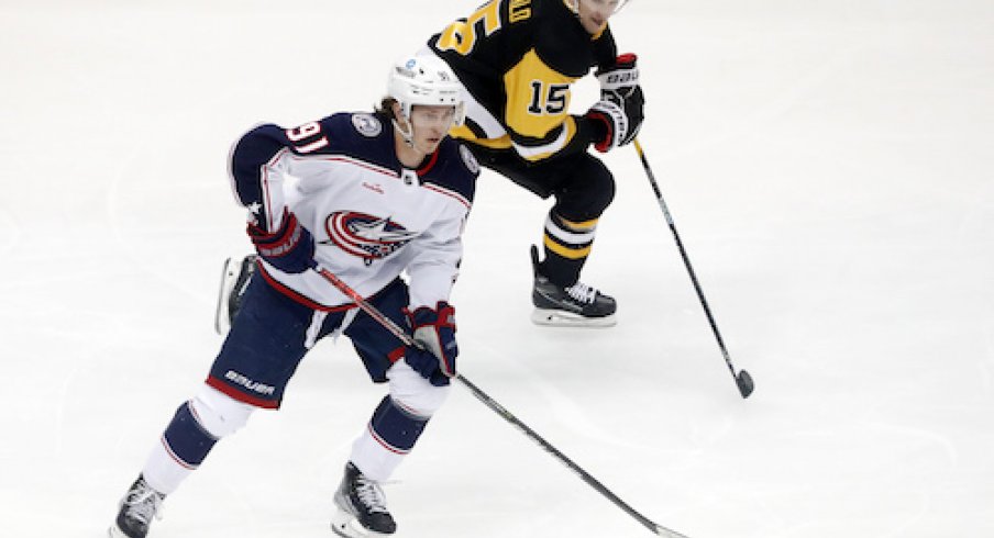 Kent Johnson carries the puck in the Blue Jackets vs. Penguins game.