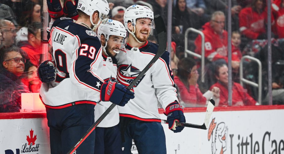 Columbus Blue Jackets' Patrik Laine celebrates his goal with Johnny Gaudreau and Jack Roslovic during the first period against the Detroit Red Wings at Little Caesars Arena.