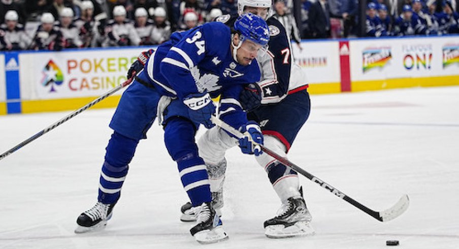 Toronto Maple Leafs forward Auston Matthews (34) gets held up by Columbus Blue Jackets forward Sean Kuraly (7) during the first period at Scotiabank Arena.