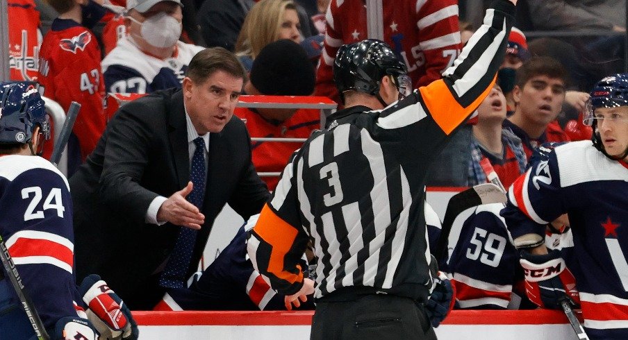 Washington Capitals head coach Peter Laviolette (L) argues a penalty call by referee Mike Leggo (3) during the game against the Vancouver Canucks during the third period at Capital One Arena.