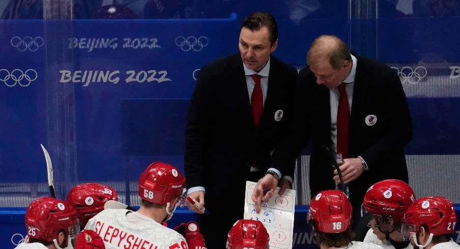 Team ROC head coach Alexei Zhamnov (R) and assistant coach Sergei Fedorov (M) talk to their team during a timeout against Team Finland in the final minute of the third period during the Beijing 2022 Olympic Winter Games at National Indoor Stadium.