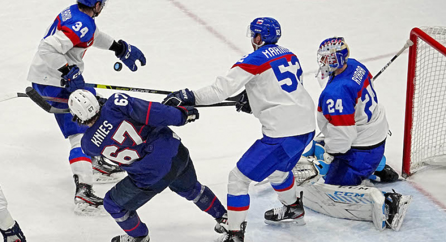 Slovakia's Simon Nemec hits United States' Matt Knies in the face with his stick in the men s ice hockey quarterfinal during the Beijing 2022 Olympic Winter Games at National Indoor Stadium.