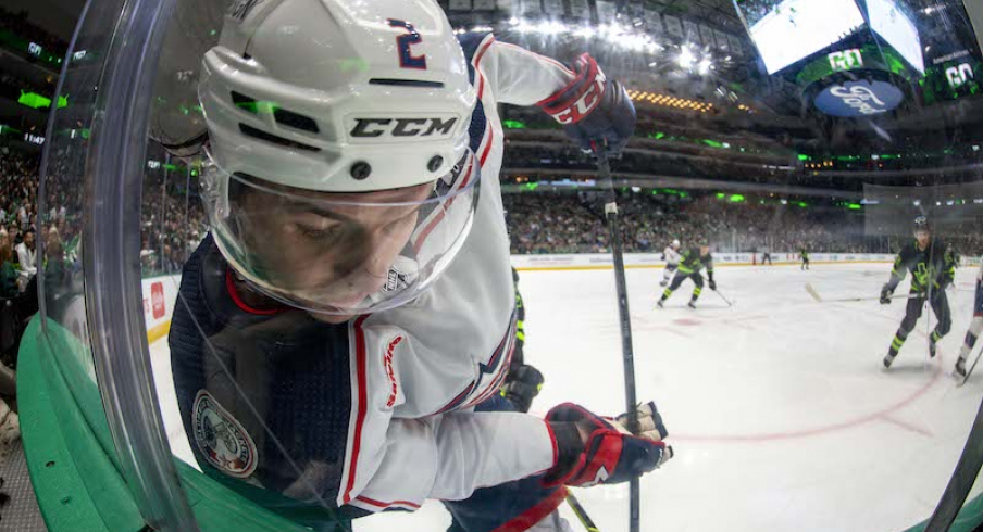 Columbus Blue Jackets' Andrew Peeke is checked into the glass as he battles for control of the puck during the second period against the Dallas Stars at the American Airlines Center.