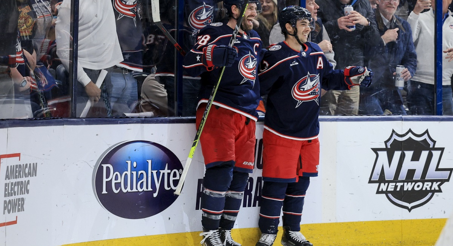 Boone Jenner celebrates with Johnny Gaudreau after scoring the game-winning goal against the New York Islanders