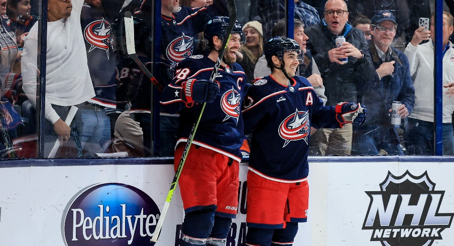 Columbus Blue Jackets center Boone Jenner (38) celebrates with teammate left wing Johnny Gaudreau after scoring the game-winning goal against the New York Islanders in the overtime period at Nationwide Arena.