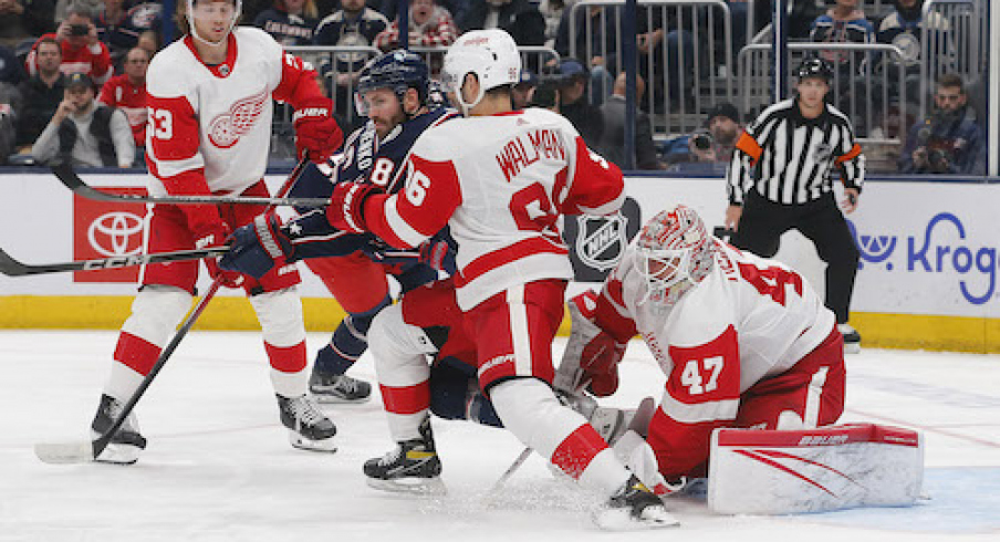 Detroit Red Wings defenseman Jake Walman (96) pushes ]Columbus Blue Jackets center Boone Jenner (38) away from the puck during the second period at Nationwide Arena.
