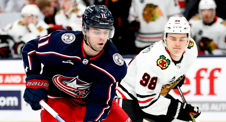 Columbus Blue Jackets center Adam Fantilli (11) shoots the puck as Chicago Blackhawks center Connor Bedard (98) trails the play during the first period at Nationwide Arena.