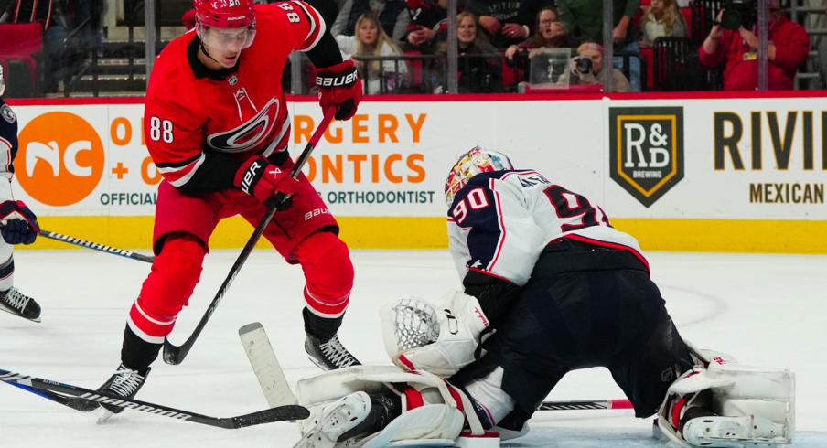 Elvis Merzlikins stops a shot attempt by Martin Necas