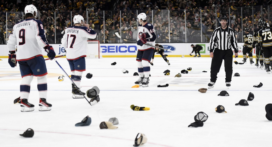 Boston Bruins fans throw their hats on the ice against the Columbus Blue Jackets at TD Garden