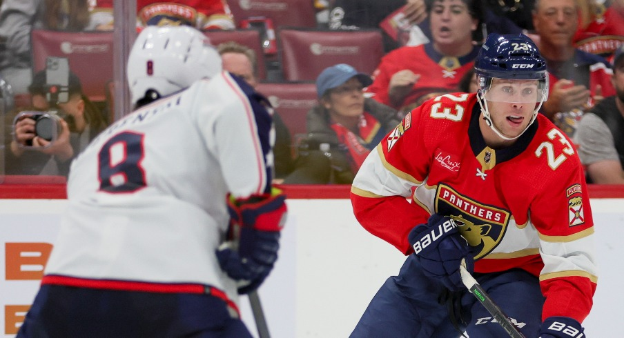 Florida Panthers center Carter Verhaeghe (23) moves the puck against Columbus Blue Jackets defenseman Zach Werenski (8) during the second period at Amerant Bank Arena.