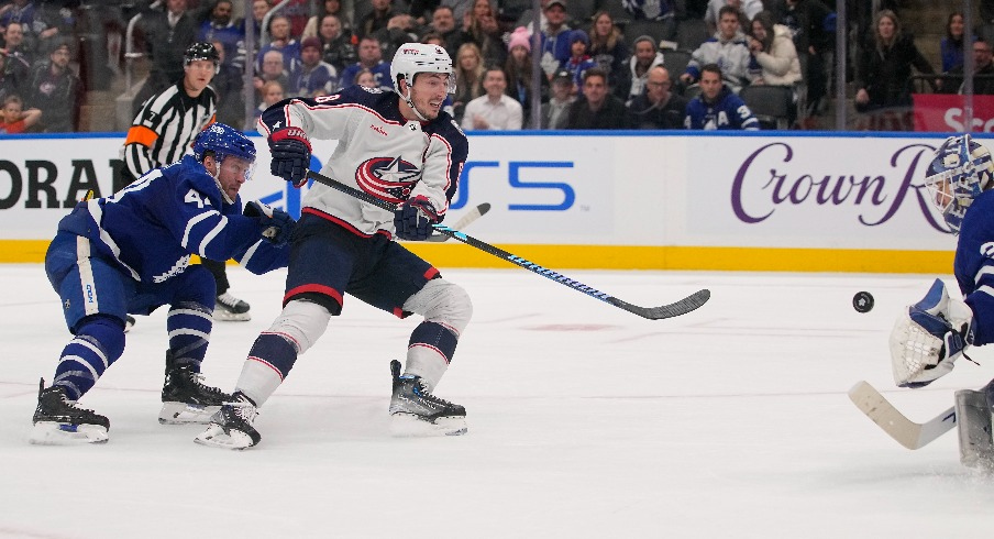 Columbus Blue Jackets defeneseman Zach Werenski (8) gets off a shot on Toronto Maple Leafs goaltender Ilya Samsonov (35) as defenseman Morgan Rielly (44) chases during the overtime at Scotiabank Arena.