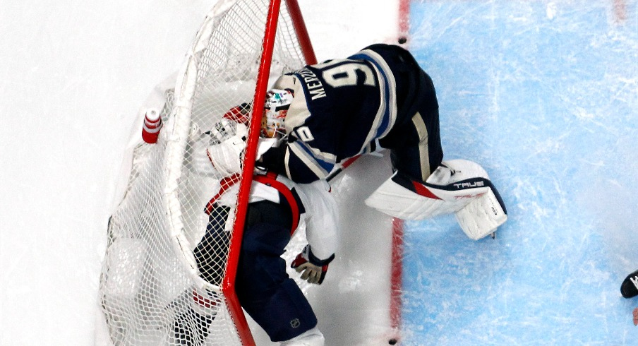 Washington Capitals right wing Tom Wilson (43) and Columbus Blue Jackets goalie Elvis Merzlikins (90) battle inside the goals during overtime at Nationwide Arena.