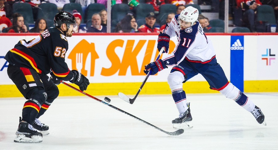 Columbus Blue Jackets center Adam Fantilli (11) shoots the puck against Calgary Flames defenseman MacKenzie Weegar (52) during the first period at Scotiabank Saddledome.