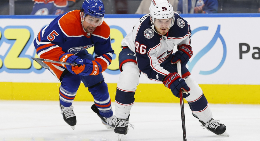 Cody Ceci tries to knock the puck away from Columbus Blue Jackets forward Jack Roslovic