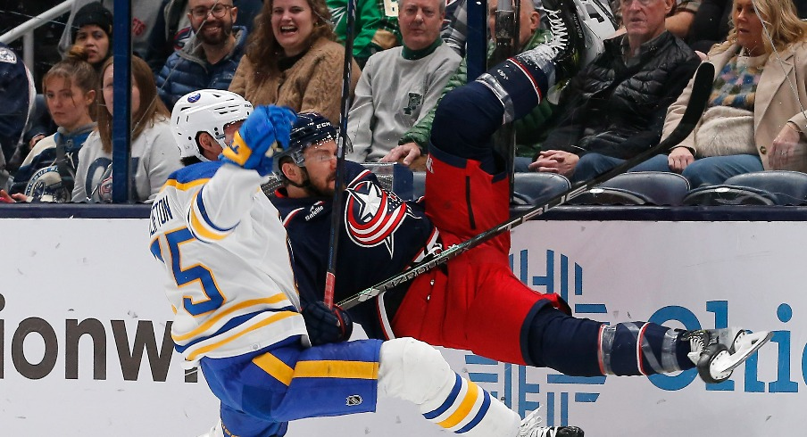 Buffalo Sabres defenseman Connor Clifton (75) checks Columbus Blue Jackets center Sean Kuraly (7) during the first period at Nationwide Arena.