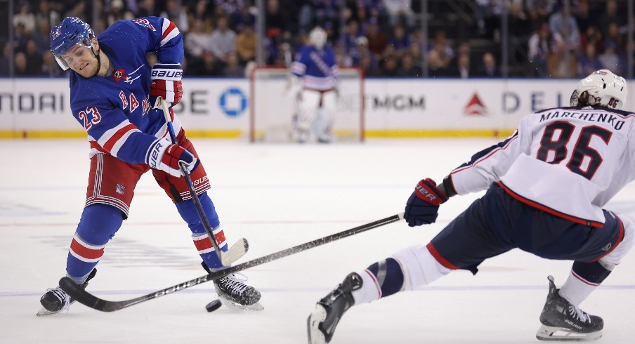 New York Rangers defenseman Adam Fox (23) takes a shot against Columbus Blue Jackets right wing Kirill Marchenko (86) during the second period at Madison Square Garden.