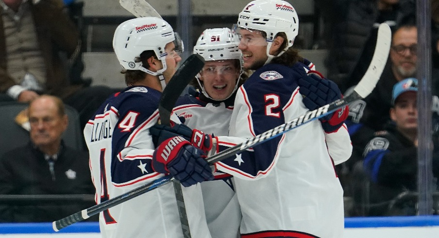 Columbus Blue Jackets defenseman Andrew Peeke (2) and forward Cole Sillinger (4) congratulate forward Kent Johnson (91) on his goal against the Toronto Maple Leafs during the first period at Scotiabank Arena.