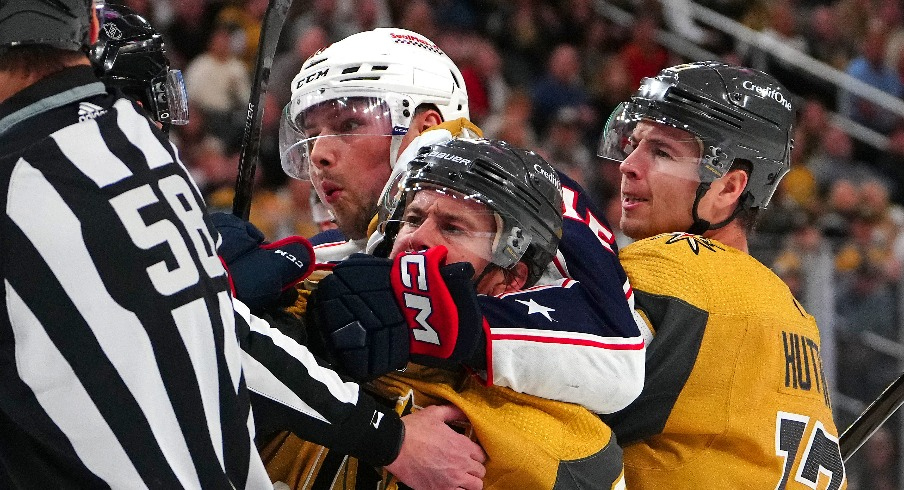 Columbus Blue Jackets center Brendan Gaunce (16) grabs ahold of Vegas Golden Knights right wing Jonathan Marchessault (81) as Vegas Golden Knights defenseman Ben Hutton (17) joins the play during the first period at T-Mobile Arena.