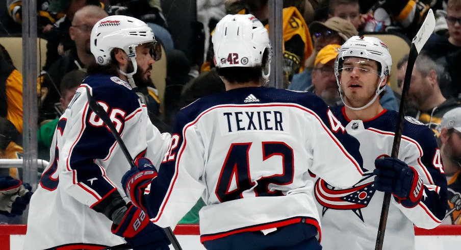 Columbus Blue Jackets right wing Kirill Marchenko (86) and center Alexandre Texier (42) congratulate center Cole Sillinger (right) on his goal against the Pittsburgh Penguins during the second period at PPG Paints Arena.