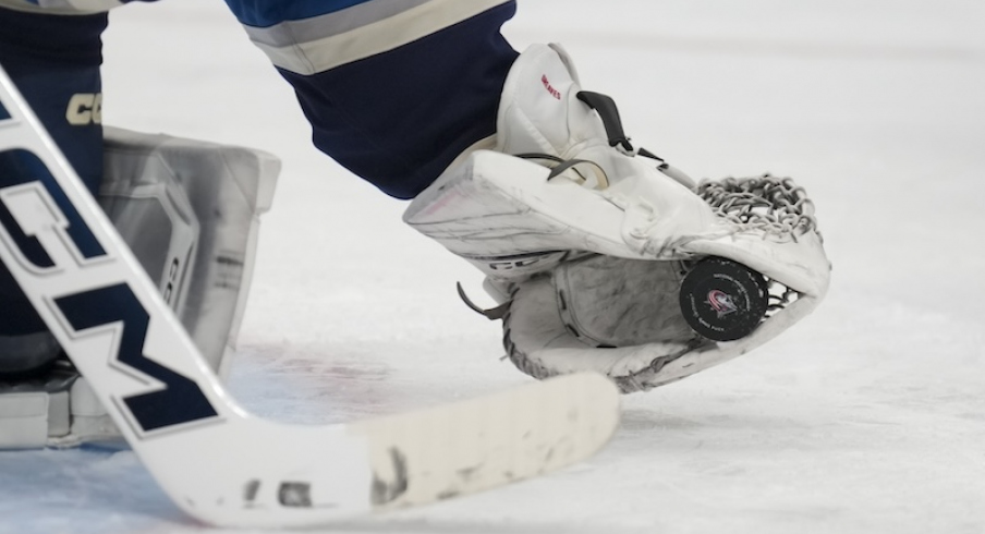 Columbus team logo is seen on the game puck as Columbus Blue Jackets' Jet Greaves makes a save in net against the New York Islanders in the third period at Nationwide Arena.