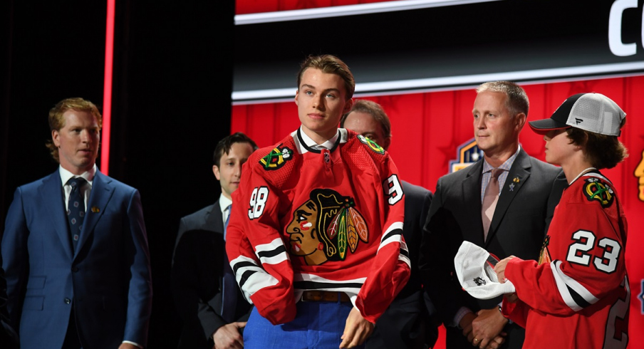 Connor Bedard puts on a Chicago Blackhawks jersey after being taken with the first pick in the 2023 NHL Draft 