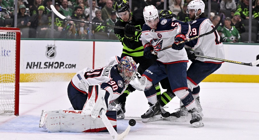 Columbus Blue Jackets goaltender Elvis Merzlikins (90) turns aside a shot as defenseman Denton Mateychuk (5) and center Adam Fantilli (19) and Dallas Stars center Mavrik Bourque (22) look on during the second period at the American Airlines Center.
