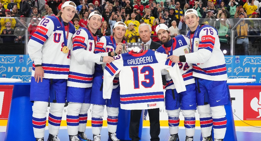 USA hockey poses with Johnny Gaudreau's jersey and the championship trophy after Sunday's 1-0 overtime win over Switzerland.