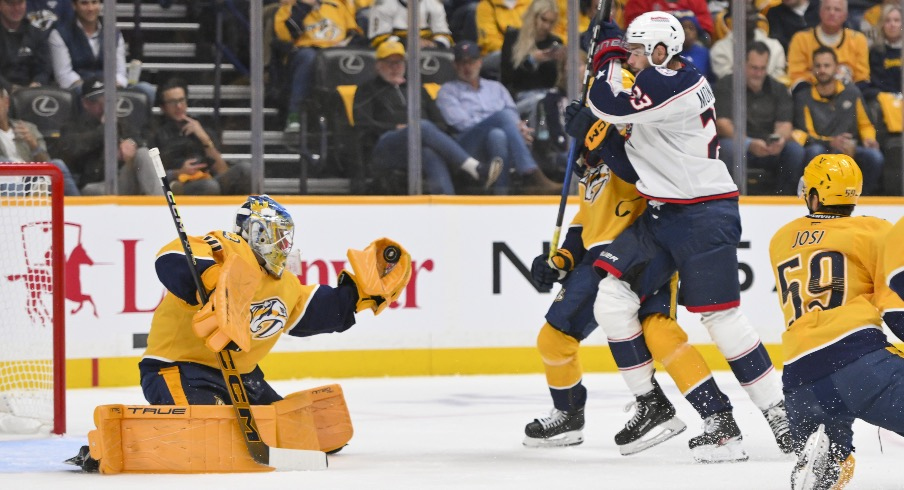 Oct 9, 2025; Nashville, Tennessee, USA; Nashville Predators goaltender Juuse Saros (74) makes a glove save from the shot of Columbus Blue Jackets center Sean Monahan (23) during the first period at Bridgestone Arena.