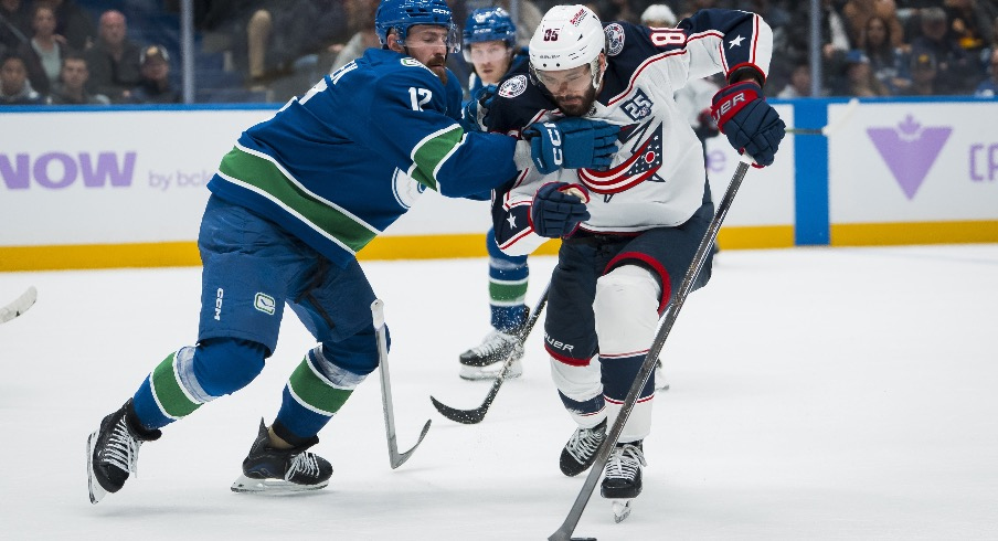 Nov 8, 2025; Vancouver, British Columbia, CAN; Vancouver Canucks defenseman Filip Hronek (17) checks Columbus Blue Jackets forward Kirill Marchenko (86) in the third period at Rogers Arena.