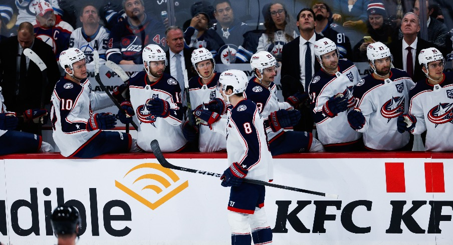 Nov 18, 2025; Winnipeg, Manitoba, CAN; Columbus Blue Jackets defenseman Zach Werenski (8) is congratulated by his team mates on his goal against the Winnipeg Jets during the third period at Canada Life Centre.