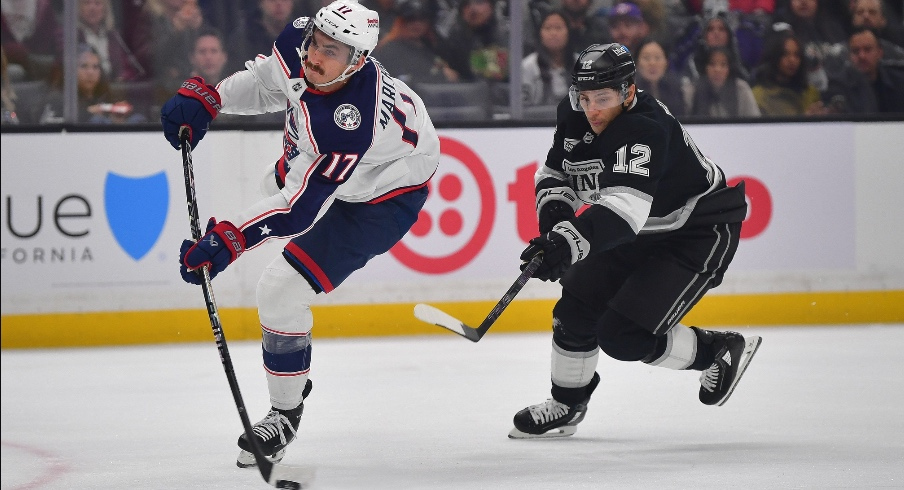 Dec 22, 2025; Los Angeles, California, USA; Columbus Blue Jackets left wing Mason Marchment (17) scores a goal ahead of Los Angeles Kings left wing Trevor Moore (12) during the first period at Crypto.com Arena.