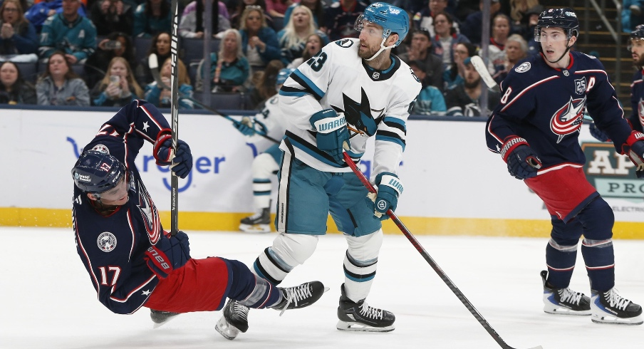 Mar 28, 2026; Columbus, Ohio, USA; Columbus Blue Jackets left wing Mason Marchment (17) falls to the ice after a check from San Jose Sharks center Barclay Goodrow (23) during the second period at Nationwide Arena.